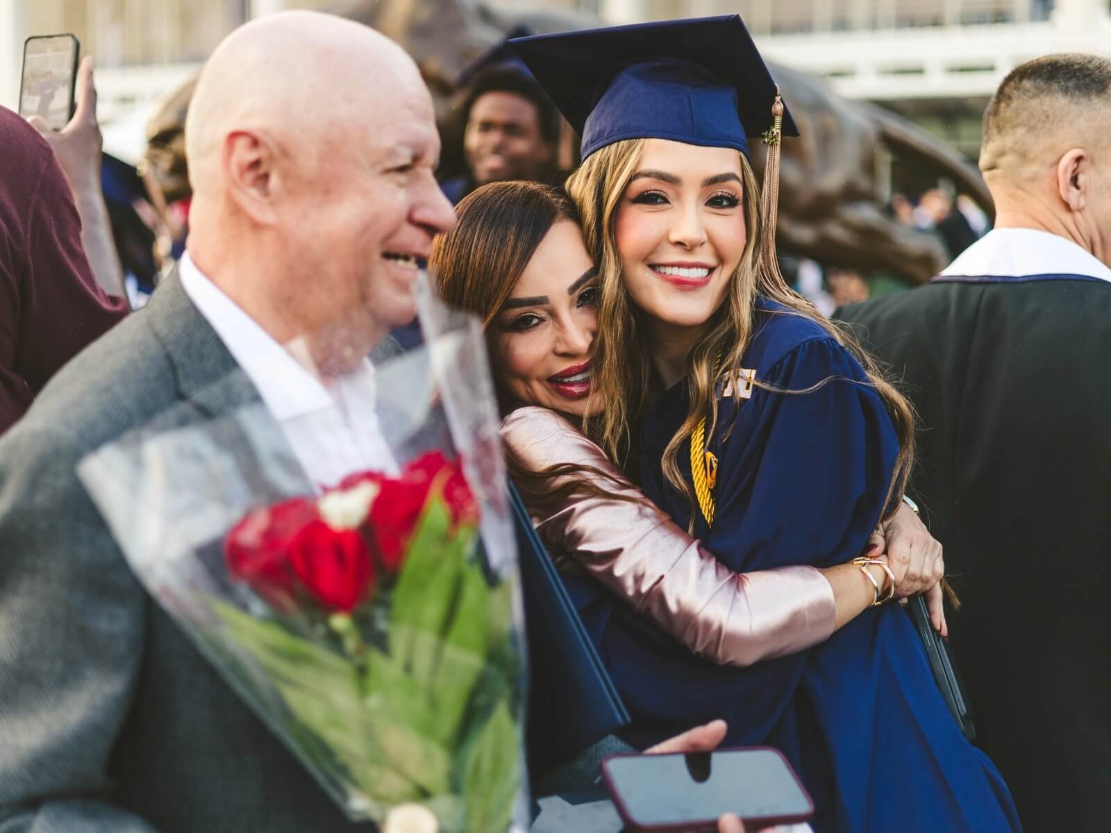 Graduate hugging relative