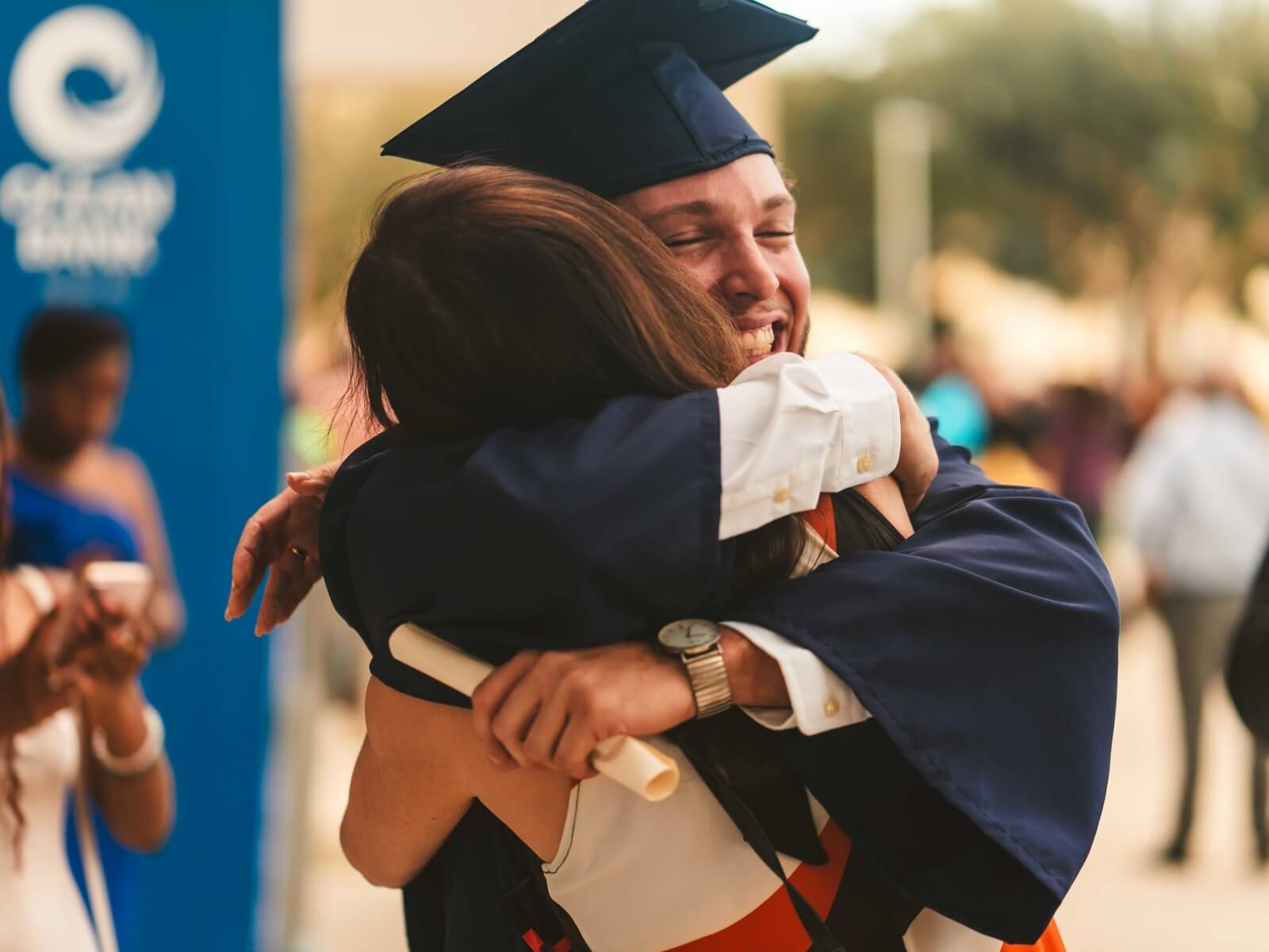 Graduate smiling and hugging relative