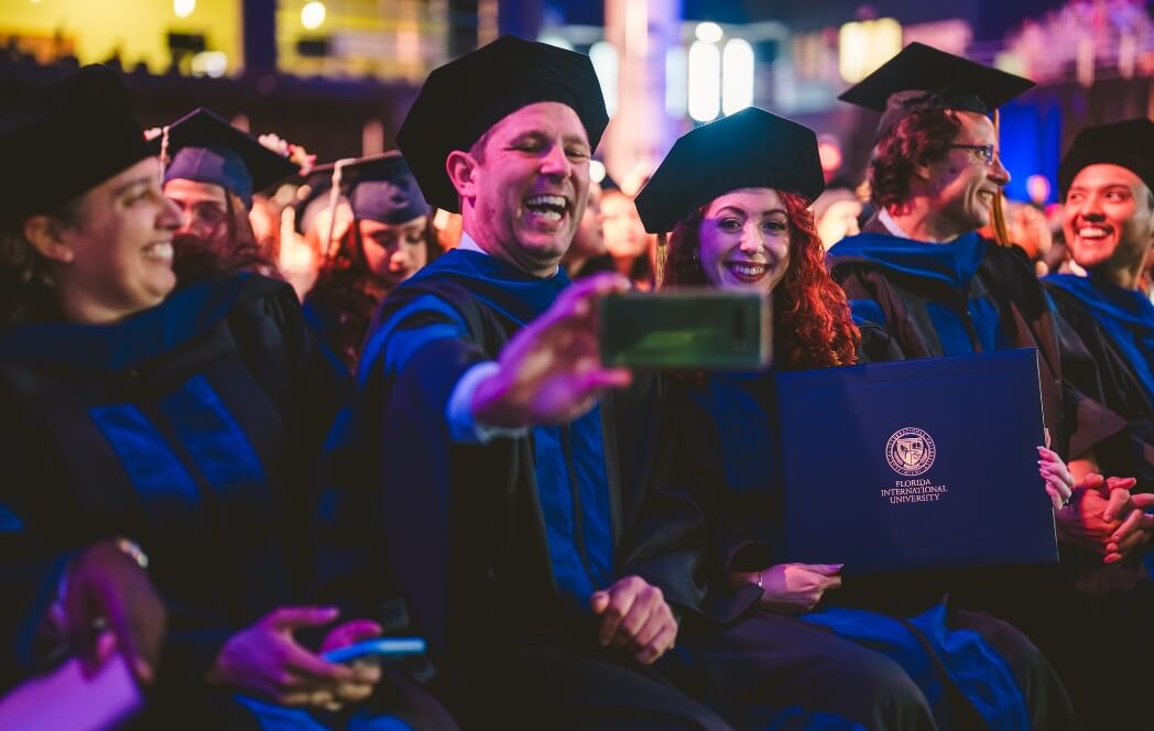 Two doctoral graduates taking a selfie