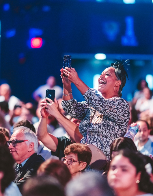 Family member taking photo of graduate from her seat